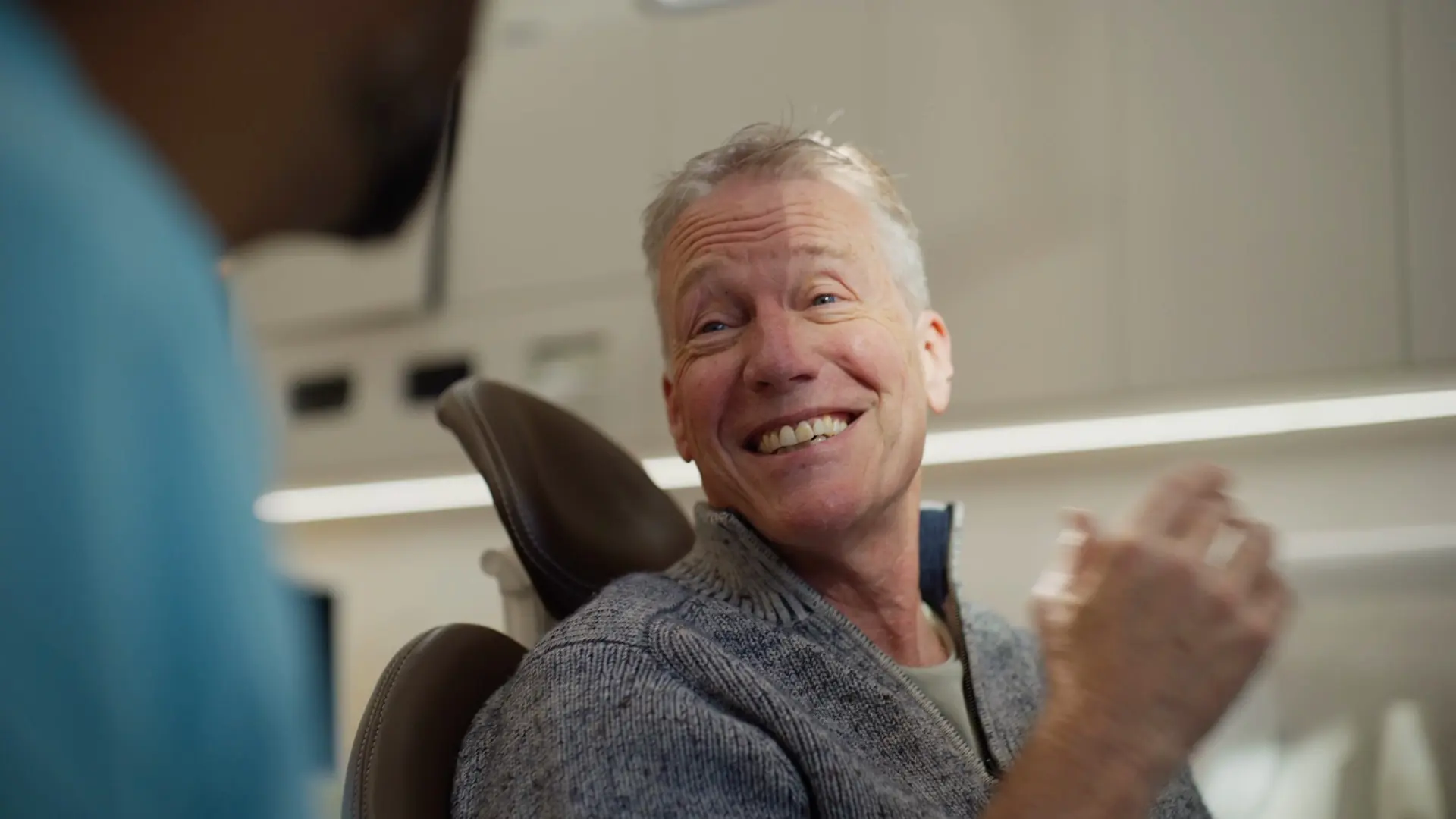 A patient laughing while talking with the dentist