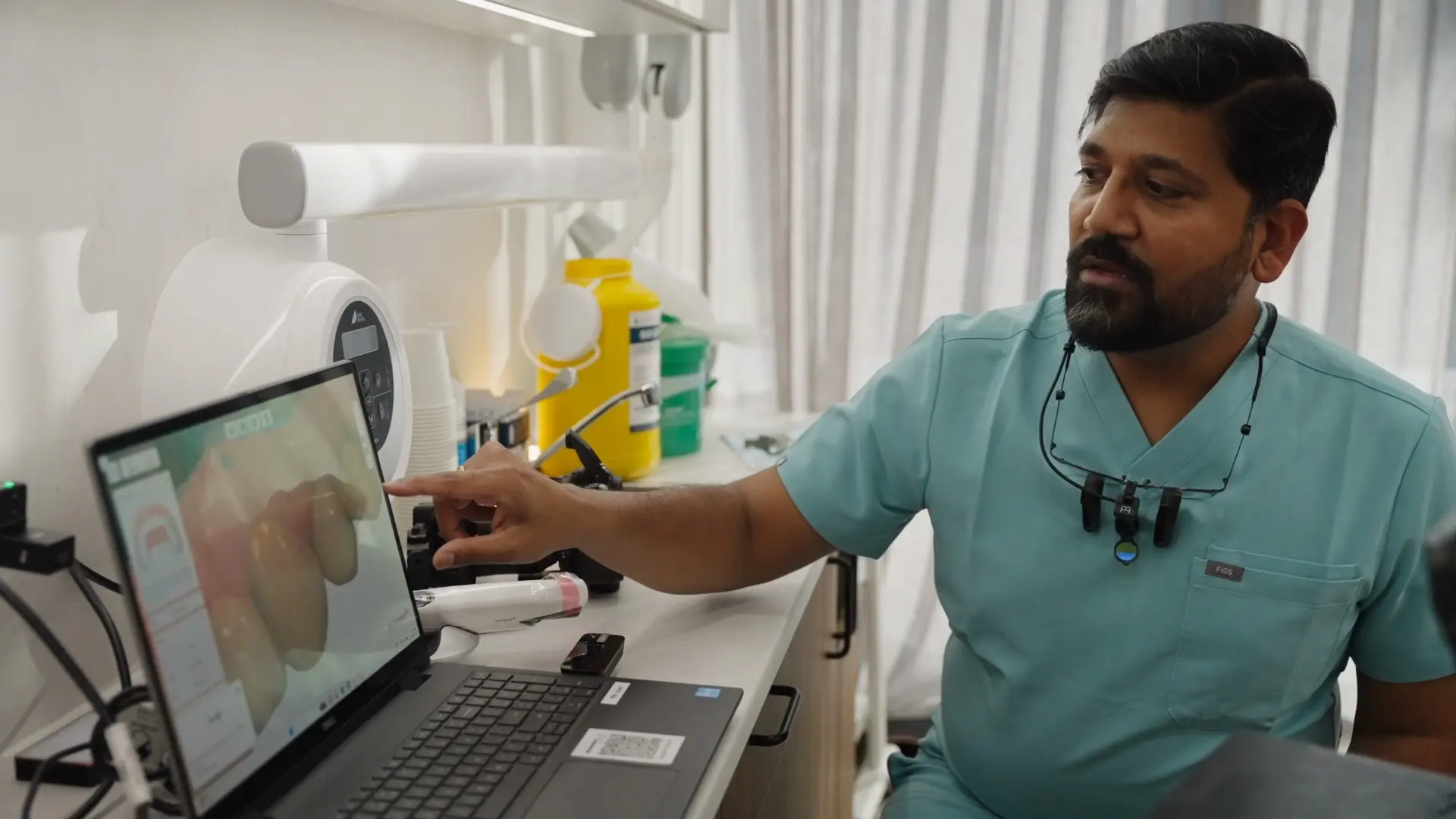 Dr Sri working on a digital smile design at a laptop