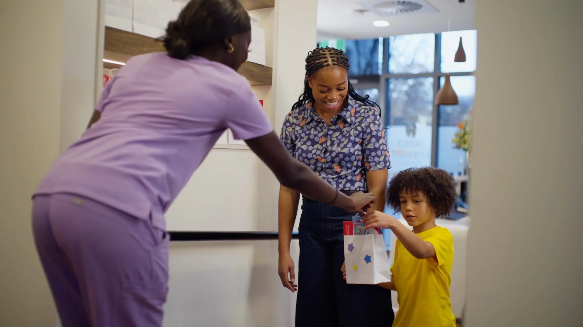 A child receiving a goodie bag at reception after their visit